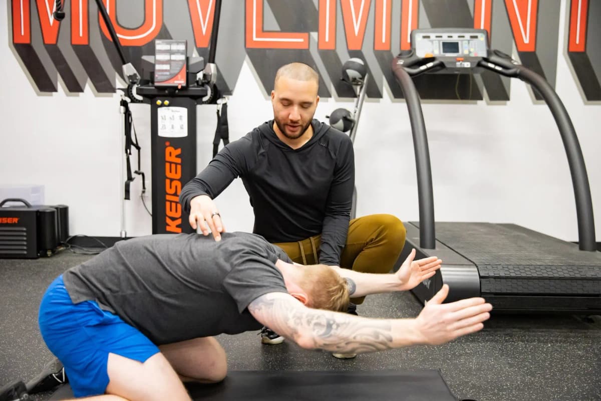 Adam Chang, one of the best physiotherapists in Mississauga, showing a patient an exercise